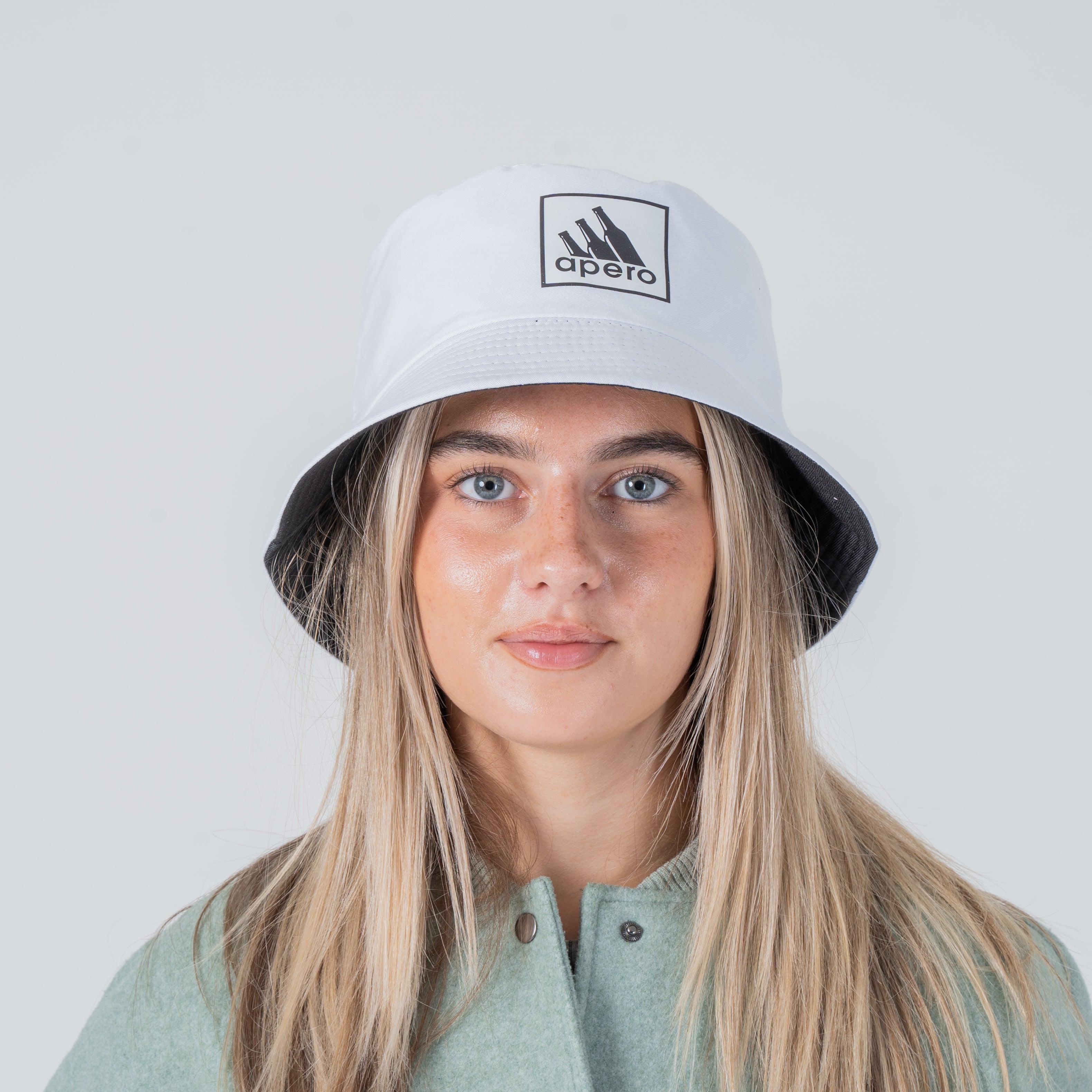 Une femme portant un bob apéro Adidas blanc sur sa tête.